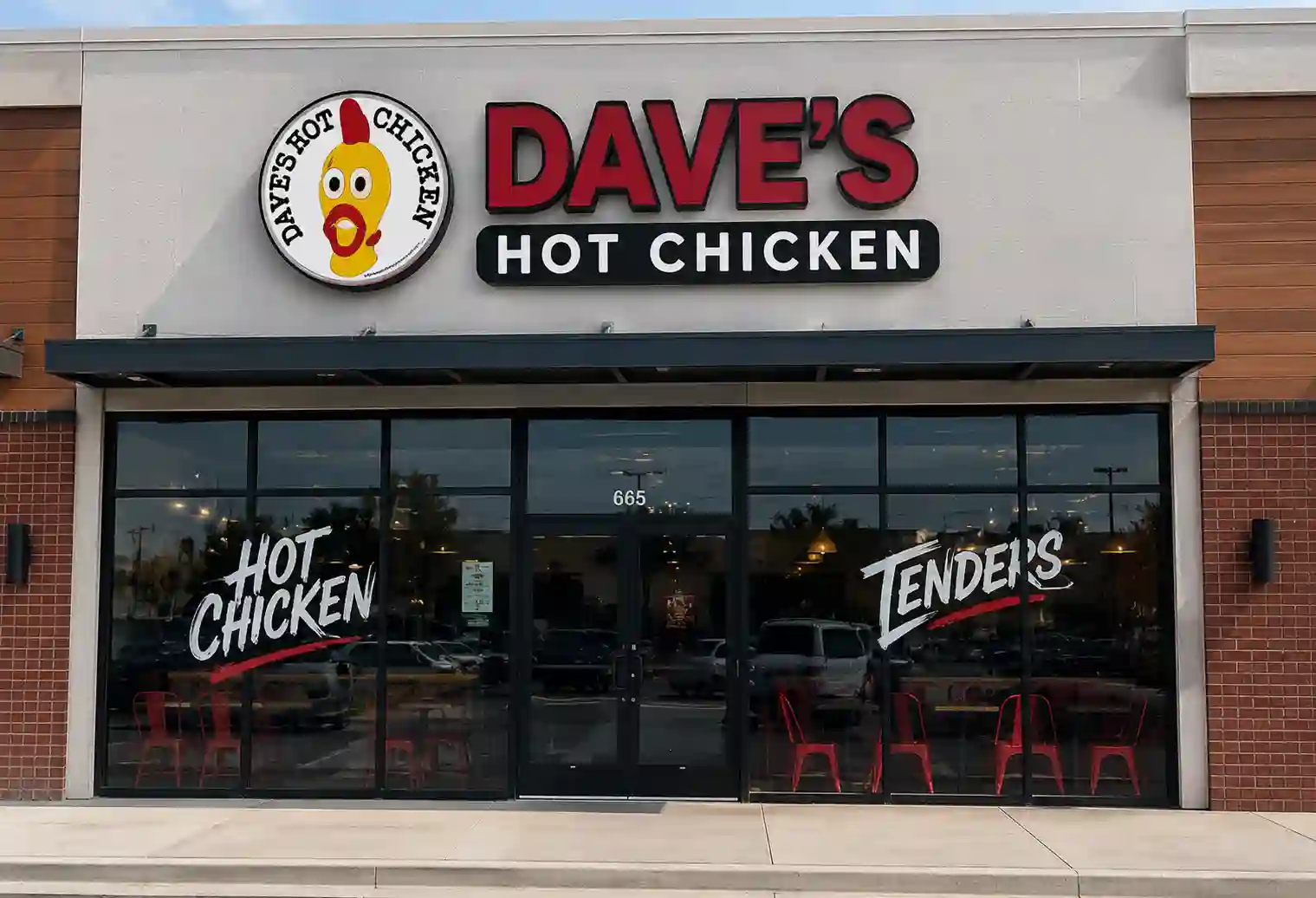 Dave’s Hot Chicken storefront exterior with red signage and glass entrance.
