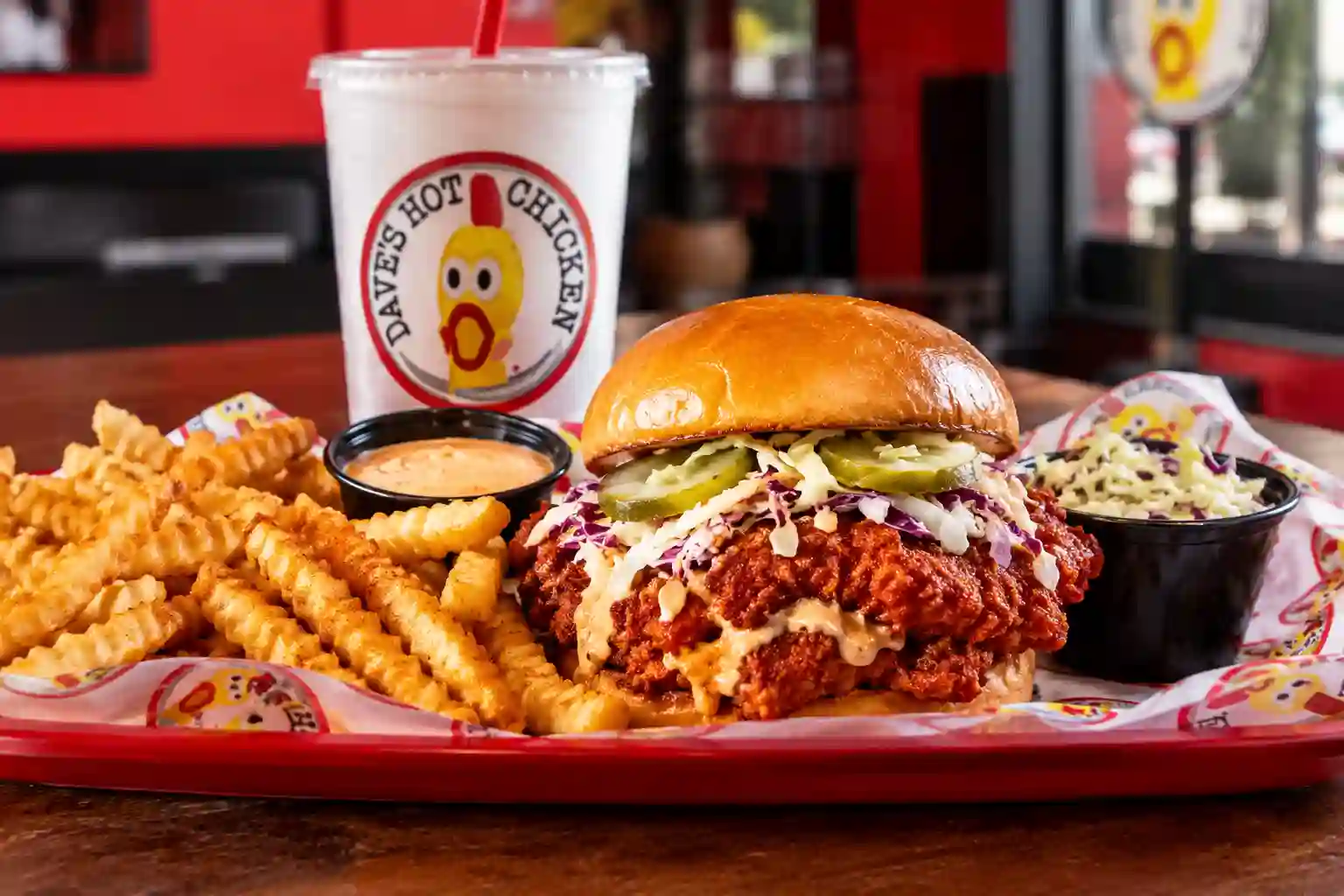 Dave’s Hot Chicken Jeffersonville meal with crispy chicken sandwich, crinkle-cut fries, dipping sauce, coleslaw, and drink.